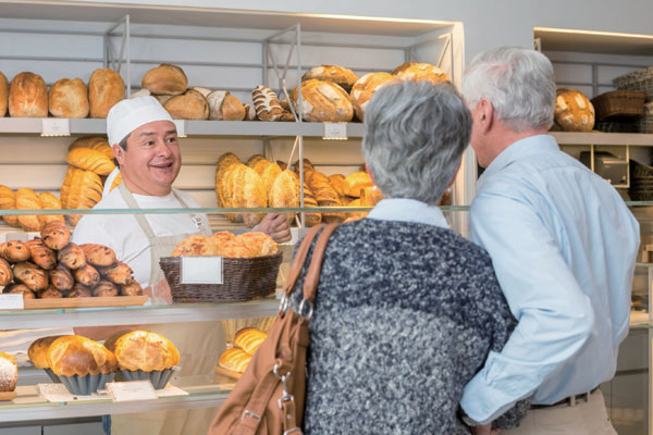 Ouder echtpaar in bakkerswinkel