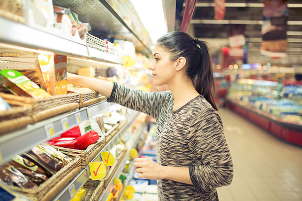 Señora eligiendo productos refrigerados en el mercado