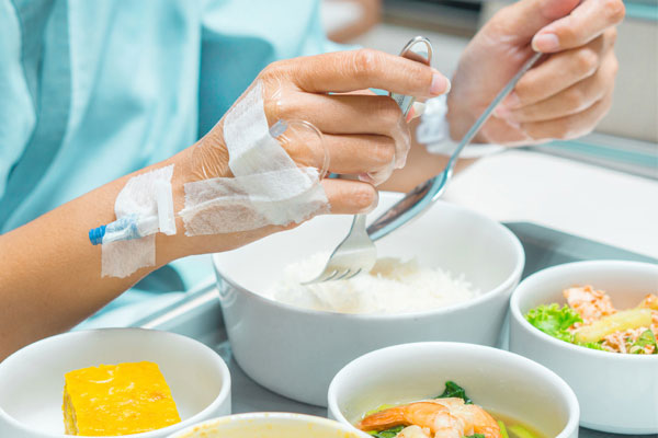 Paciente comiendo en la cama de un hospital