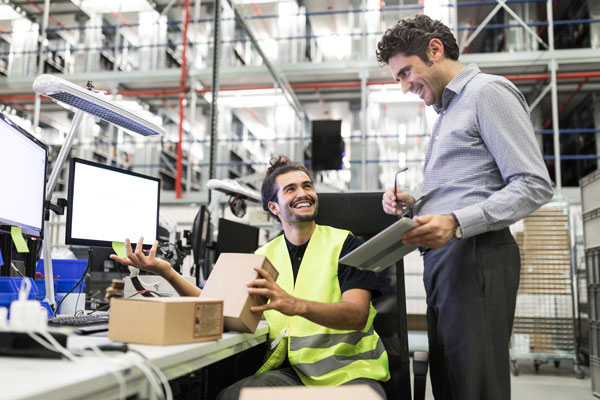 Staff using computer equipment in warehouse