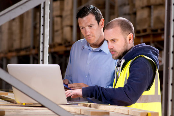 Staff using computer equipment in warehouse