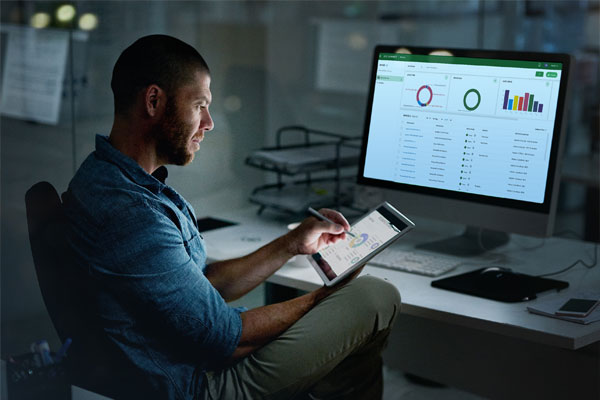 Man viewing SOTI Connect reports on computer screen