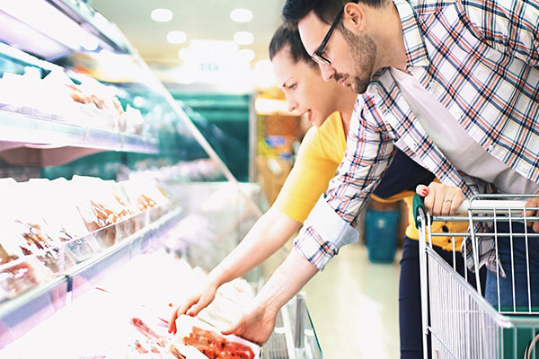 Coppia che sceglie la carne da acquistare in un supermercato