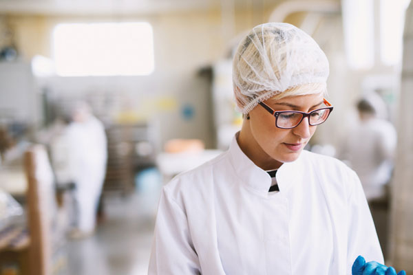 Signora che prepara il cibo in uno stabilimento